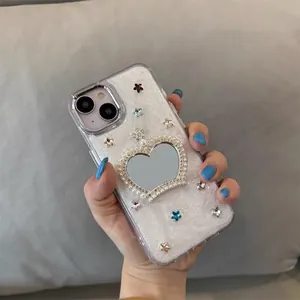 Sparkly iPhone case with heart mirror, pearls, and rhinestones held in hand
