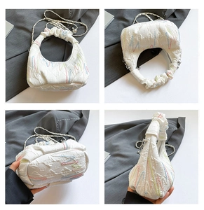 Detail shots of white ruched crescent bag with colorful embroidery and silver chain