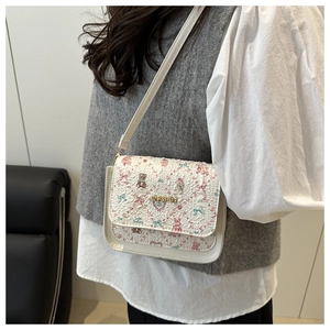 Detail of white cross-body bag featuring cute bear prints and gold metal logo lettering