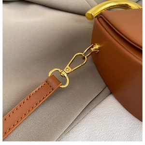 Detailaufnahme der braunen Ledertasche mit glänzendem goldfarbenem Metallhaken
