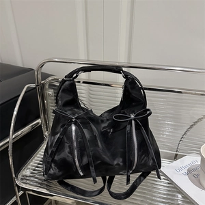 Sac hobo noir en satin avec nœud et détails zippés sur support métallique