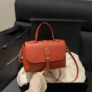 Sac à main en cuir rouge brique avec boucle fer à cheval dorée et bandoulière