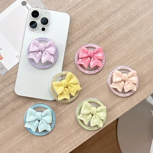 Magnetic bow phone grip socket in vibrant macaron colors on a wooden surface
