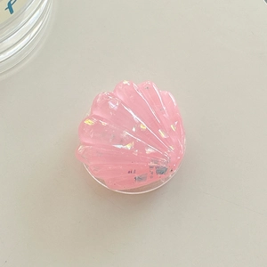 Close-up of pink glitter resin phone grip with seashell texture and expandable stand