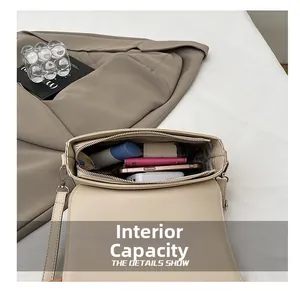 Detail view of the spacious internal capacity of this cream small square crossbody bag