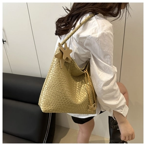 Detail of metallic gold woven hobo bag with distinctive star pendants and drawstring