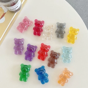Transparent bear phone grips with gold foil inlay in various colors on white table