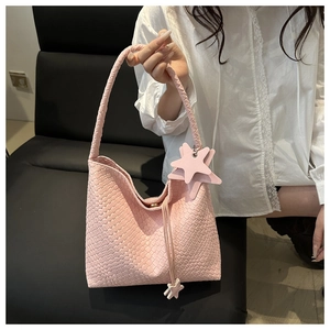 Detailed view of pink woven tote bag with star charm and drawstring tassel decoration