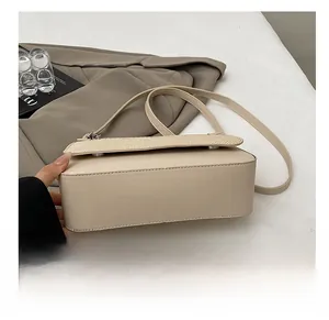 Detail shot of the durable base on this apricot textured crossbody small square bag