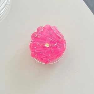 Detailed top view of pink resin shell phone socket with golden foil and scallop texture