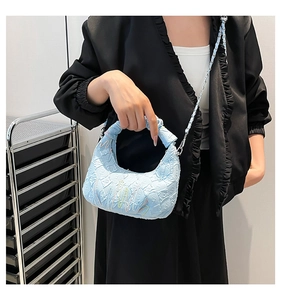 Detail of light blue pleated bubble fabric handbag with silver metal chain strap