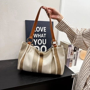 Large striped canvas tote bag with brown leather handles for women's daily commuting