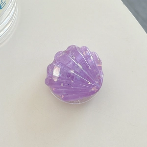 Macro shot of purple resin shell phone grip showing glitter texture and foldable stand