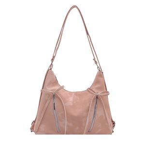 Pink faux leather tote bag with double zippers and decorative bow on white background