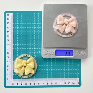 Close-up showing 50mm width and 28.5g weight of bow-shaped magnetic phone sockets