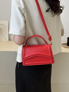 Detailed back view of a woman wearing the vibrant red rectangular crossbody bag with top handle