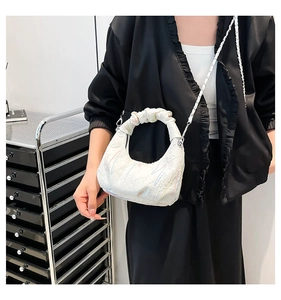 Detail of white cloud bag featuring colorful line embroidery and silver chain strap