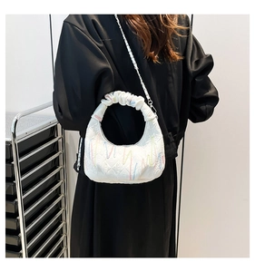 Detail of white quilted handbag featuring colorful embroidery and elegant chain strap