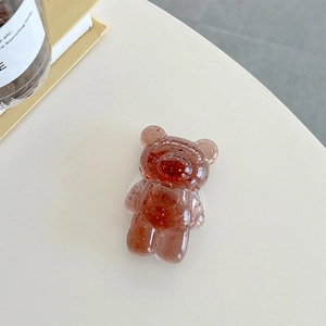 Macro shot of bear-shaped phone grip with gold foil inside transparent amber resin