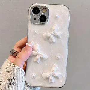 White pearlescent iPhone case with 3D bows and pearls shown in hand on neutral background