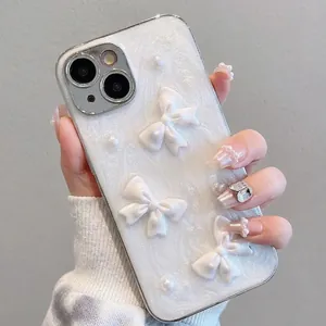 iPhone 16 Pro Max case with 3D bows and pearls on a pearlescent white surface