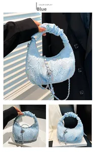 Detail of light blue pleated cloud bag featuring colorful embroidery and silver ball chain