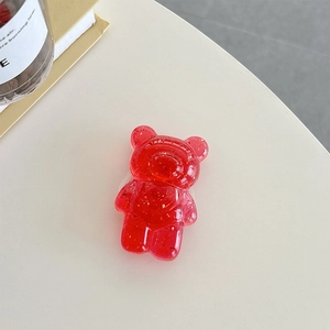 Macro detail of red translucent bear phone grip with sparkling gold foil flakes