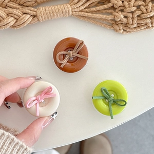 Solid color button bow retractable phone grip holder in caramel, cream, and green colors