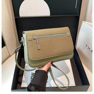 Detail of matcha green crossbody bag with textured beige flap and silver zipper accent