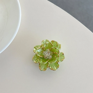 Macro detail of 3D light green flower phone stand with gold edges and crystal center