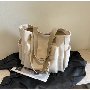 Detailed view of the large capacity canvas tote bag with multi-pocket utility design