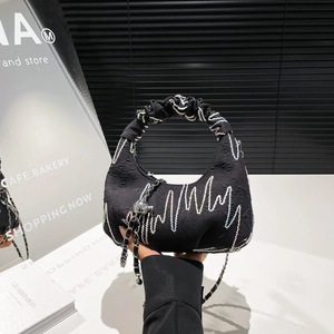 Fashionable black half-moon pleated handbag with wave embroidery and silver chain detail