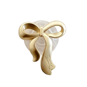 Minimalist gold bow-shaped folding phone grip stand with an elegant matte metallic finish