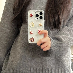 Close-up of glitter iPhone case with 3D plaid heart and star resin charms held in hand