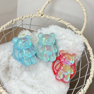 Dettaglio del supporto per telefono orsetto laser con finitura iridescente su peluche