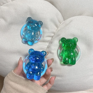 Three bear-shaped phone grips with gold foil accents in blue and green resin colors