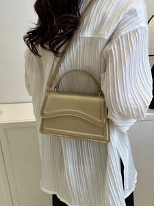 Champagne gold handbag with wavy quilted texture and versatile crossbody strap