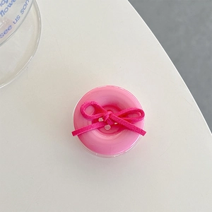 Detailed top view of pink button phone grip with vibrant fuchsia velvet bow tie detail