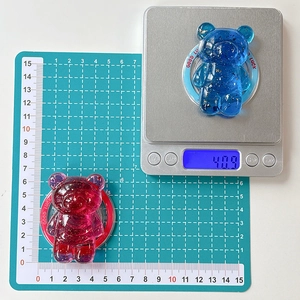 Detail view of bear phone stand on a scale showing 40.9g weight and size dimensions