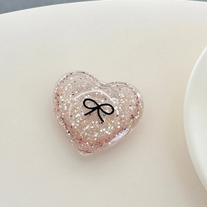 Detail of pink glitter heart phone socket with a minimalist black bow pattern
