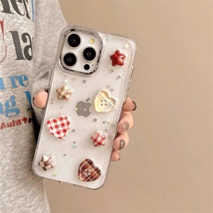 Handheld iPhone case featuring plaid heart and star patches with silver glitter accents