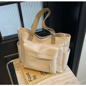 Detail view of large canvas tote bag with side pockets and durable woven handles