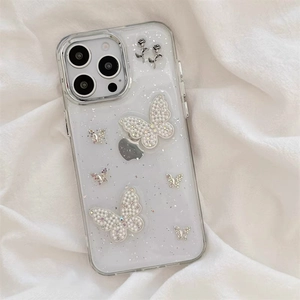 Glitzernde iPhone-Hülle mit Perlen-Schleifen-Halterung und Blumen auf weißem Stoff