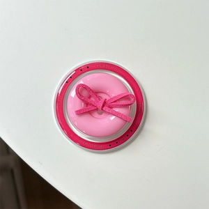Macro view of pink button phone grip with suede bow detail on a transparent base