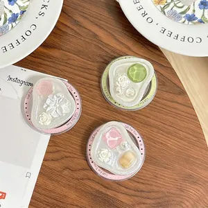 Three magnetic floral phone sockets with pearls and gems on a wooden tabletop