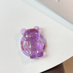 Close-up of purple resin bear phone grip with gold flakes and Good Luck text detail