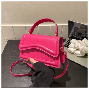 Detail of rose pink handbag with wavy quilted texture and elegant gold hardware