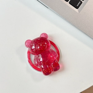 Macro view of a pink bear phone grip with gold flakes and a red Good Luck base