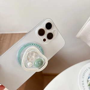 Macro detail of magnetic phone socket with pink heart crystal and green base on a phone