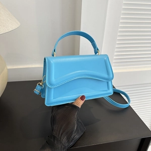 Detail of light blue structured handbag showing smooth faux leather and gold hardware